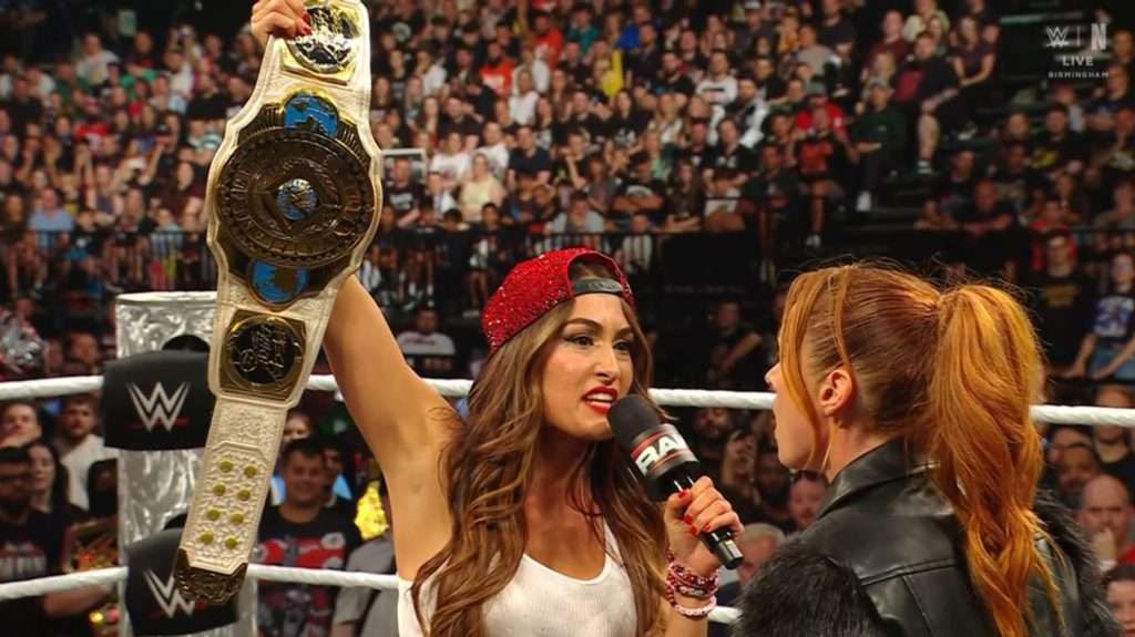 Nikki Bella with the Intercontinental Championship and Becky Lynch on WWE RAW